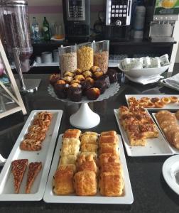 a table topped with trays of pastries and other foods at Hotel Monte Lírio in Espinho