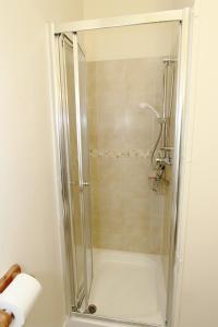 a shower with a glass door in a bathroom at West Point Hotel Bed and Breakfast in Colwyn Bay