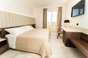 a hotel room with a bed and a desk at Hotel Falli in Porto Cesareo
