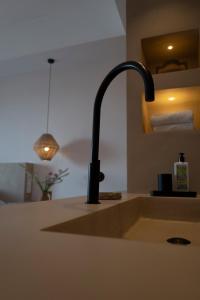 a white sink sitting under a lamp in a kitchen at Can Arabí in Ibiza Town