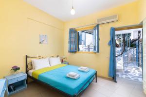 a bedroom with a bed with towels on it at Afroditi Apartments in Makry Gialos