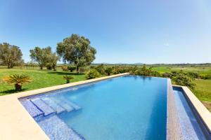 a swimming pool with a view of a field and trees at Villa Son Gilí in Maria de la Salut