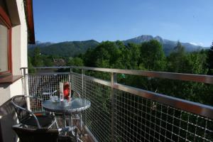 una mesa en un balcón con vistas a las montañas en Apartament Top Zakopane, en Zakopane