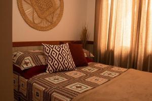 a bed with pillows on it in a bedroom at Pousada Mapuche in São José