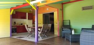 ein farbenfrohes Haus mit einem Tisch und Stühlen in der Unterkunft Gites Cabazat in Bouillante