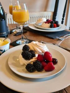two plates of fruit on a table with glasses of orange juice at Goodwins' by Spires Accommodation a comfortable place to stay close to Burton-upon-Trent in Swadlincote