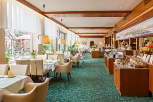 a restaurant with tables and chairs and a bar at Parkhotel Crombach am Salingarten in Rosenheim
