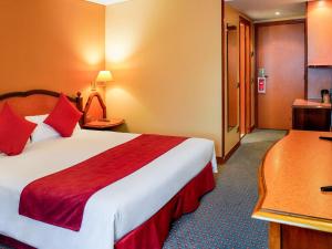 a hotel room with a large bed with red pillows at Mercure Andorra in Andorra la Vella