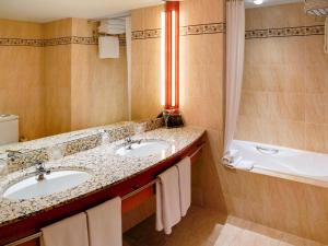 a bathroom with two sinks and a large mirror at Mercure Andorra in Andorra la Vella