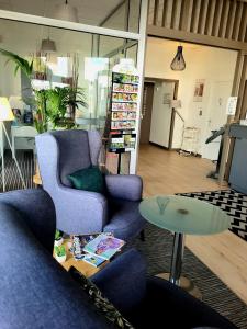 a living room with two chairs and a table at The Originals City, Hôtel Solana, Niort Est MendesFrance in Niort