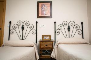 two beds sitting next to each other in a room at Hostal Restaurante El Paso in Bailén