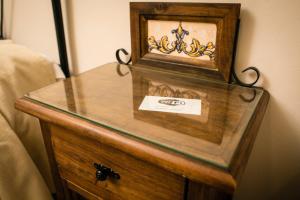 a wooden dresser with a glass top on top of it at Hostal Restaurante El Paso in Bailén