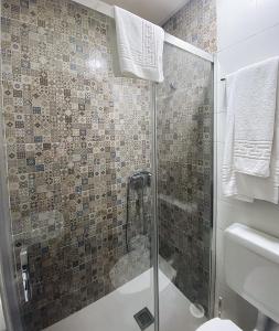 a bathroom with a shower with a glass door at Hostal Restaurante El Paso in Bailén