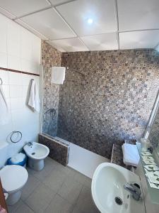 a bathroom with a sink and a toilet and a tub at Hostal Restaurante El Paso in Bailén
