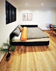 - une chambre avec un grand lit et une plante dans l'établissement Appart Chill & Free - Proche Centre Valenciennes - Parking Gratuit, à Valenciennes