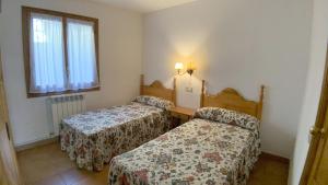 a hotel room with two beds and a window at C12 - Apartamento Casa Llorgodo 3 - Villmor in Cerler