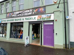 a store with a purple door on a street at Dunlap Apartments in Strabane