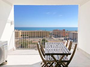 una mesa y sillas en un balcón con vistas al océano en Global Properties, Increible apartamento con vistas al mar, Canet d'en Berenguer, en Canet de Berenguer