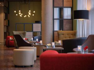 een lobby met banken en tafels en een kroonluchter bij Dorint Parkhotel Frankfurt / Bad Vilbel in Bad Vilbel