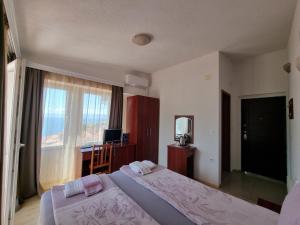 sypialnia z 2 łóżkami, biurkiem i oknem w obiekcie Villa Mesokastro w Ochrydzie