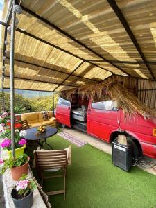 瑰瑪的住宿－Honeymoon van，停放在带桌椅的帐篷下的面包车