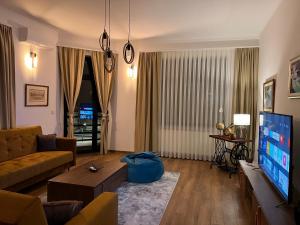 a living room with a couch and a tv at Penthouse City Center in Bihać