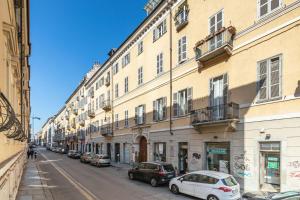 ulica miejska z samochodami zaparkowanymi przed budynkami w obiekcie Loft Alma Rosa vicino a Piazza Vittorio w Turynie