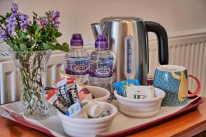 a tray with cups and bottles of water on a table at Woodside Lodge in Thurstaston