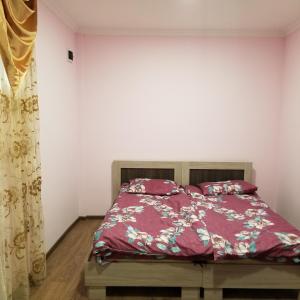 - une chambre avec un lit et une couette rouge dans l'établissement Maria, à Erevan