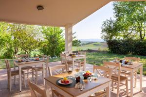 un patio con mesas y sillas y vistas. en Villa LeMarche b&b, en Rustico