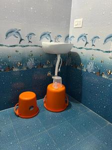 a bathroom with a sink and dolphins on the wall at Darshan's Home Stay in Madikeri