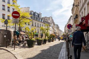 Ein Mann, der in einer Stadt auf einer Straße läuft in der Unterkunft Veeve - Almond Blossom in Paris