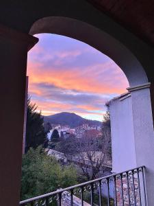 uma vista para o pôr-do-sol através de um arco de uma varanda em ca n'Arago, edificio modernista del arquitecto Rafael Maso em Santa Coloma de Farners