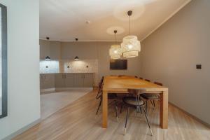 una cucina e una sala da pranzo con tavolo e sedie in legno di River Eyes Suites a Vila Nova de Gaia
