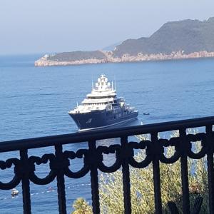 a large boat in the water next to a fence at Vila Horizont in Sveti Stefan