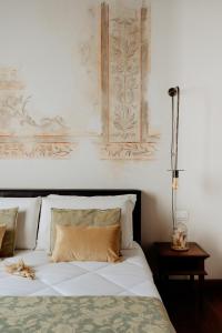 a bedroom with a white bed and a lamp on a table at Relais Giulia in Rome
