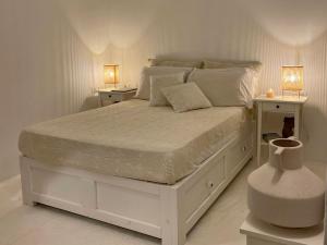 una camera con un letto bianco con due comodini di Islander House ad Agios Georgios