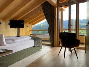 a bedroom with a bed and a large window at Torghele's Wald & Fluh in Balderschwang