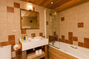 a bathroom with a sink and a tub and a mirror at Chalet privatif pour 8 personnes aux Coches - Paradiski in Les Coches