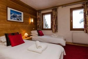 two beds in a room with two windows at Chalet privatif pour 8 personnes aux Coches - Paradiski in Les Coches