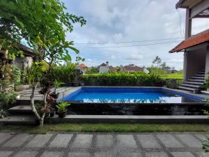 a swimming pool in the backyard of a house at Gerhana Sari 2 Bungalows in Ubud