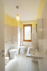 uma casa de banho com 2 WC, um lavatório e um WC. em Casa Gli Ulivi em Montepulciano