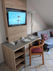 a living room with a desk with a television on it at Hotel-Restaurant Im Goldenen Grund in Körperich