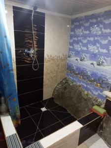 a bathroom with a shower with a fish themed wall at FOREST Guest House in Mirzakishlak