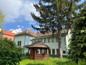 uma grande casa branca com um gazebo no quintal em Vaskapu Fogadó em Vasvár