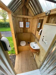 a small bathroom with a toilet and a sink at Countryside Cabin in Taunton