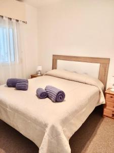 sypialnia z łóżkiem z fioletowymi ręcznikami w obiekcie Surf w mieście Estepona