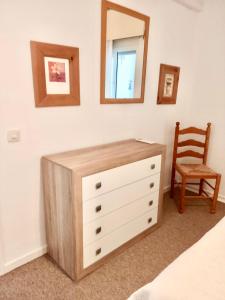 komodę w sypialni z lustrem i krzesłem w obiekcie Surf w mieście Estepona