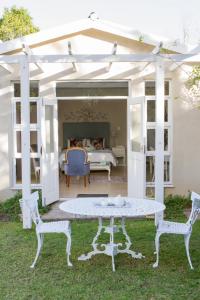 un patio bianco con tavolo e 2 sedie di Cherry Berry Lodge a George