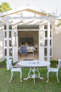 a white patio with a table and two chairs at Cherry Berry Lodge in George